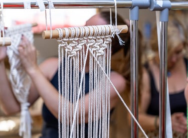 Tapiz de macramé hecho a mano en proceso en un taller de artesanía con nudos intrincados de cuerda 