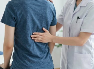 Therapist assisting a patient with muscle rehabilitation exercises in a bright clinic room.