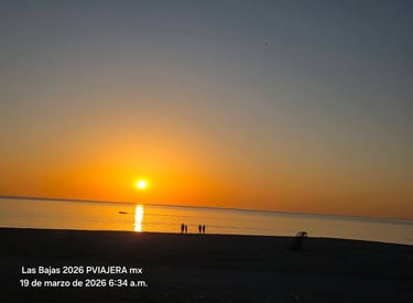 Atardecer en playa a contra luz se ve una lancha y varias personas