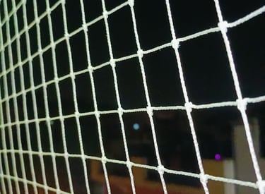 Close-up of a sturdy pigeon netting installed on a KR Puram balcony.