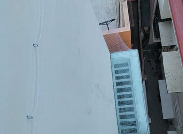Wide shot of workers installing pigeon nets on a residential balcony in Hebbal.
