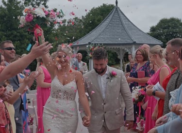 bride and groom walking while guest throw confetti