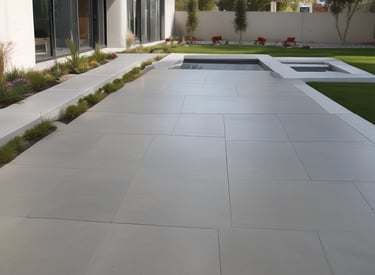 Smooth concrete driveway with decorative pavers in a residential setting.