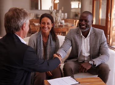 Couple meeting with a local home buyer and reviewing a written offer for their house.