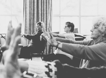 Chair Yoga class hands raised and wrists bending