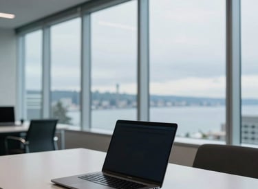 A modern, sophisticated office interior in Seattle with a view of the Puget Sound through floor-to-ceiling windows, white smoke and light steel blue tones, a clean desk with a single encrypted laptop, professional atmosphere.