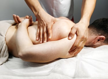 Terapeuta de masaje deportivo profesional que realiza manipulación de tejido profundo del hombro