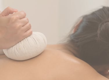 A massage therapist applies a warm Thai ball herbal compress at Zen Massage Therapy in Norfolk