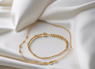 Close-up of delicate gold jewelry resting on a cream linen fabric.