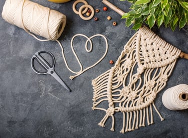 Herramientas para creación de macrame, junto con bordado en color hueso