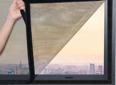 Bright room with a window fitted with a clean, white velcro mosquito net letting in sunlight.