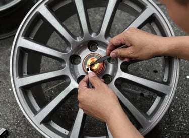 Technician carefully straightening a bent alloy wheel