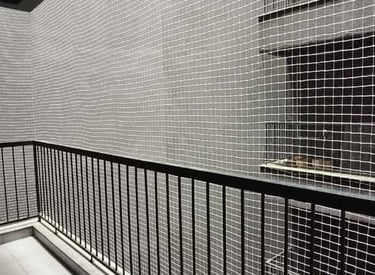 Technician installing a safety net on a high-rise balcony in Ahmedabad.