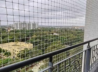 Technician installing a sturdy balcony safety net on a residential building in Thiruvanmiyur.