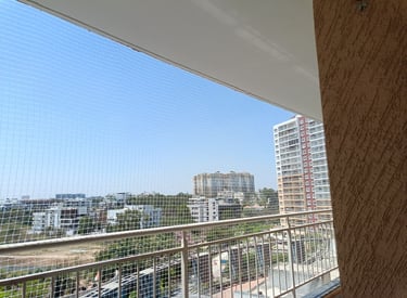 Close-up of a tightly woven pigeon net installed on a sunny balcony in Bengaluru