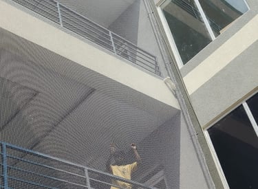 Close-up of a tightly woven anti-pigeon net installed on a residential balcony in Thoraipakkam.