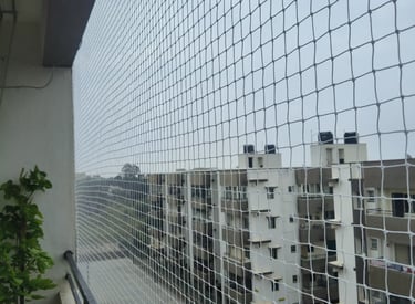 Technician carefully fitting a pigeon net on a modern balcony railing