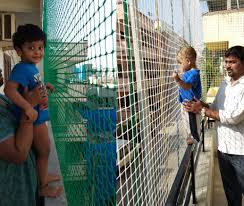 Wide shot of a high-rise balcony fitted with safety nets to protect children.