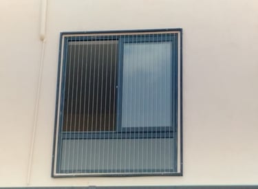 A technician carefully measuring a window frame installing an invisible grill in Mylapore chennai