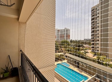 Close-up of a sturdy safety net securely fastened on a high-rise apartment balcony.