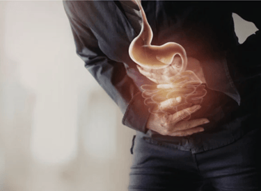 Person clutching abdomen with glowing stomach and intestines illustration showing digestive pain