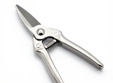 Close-up of a sharp pruning shear resting on freshly cut branches with green leaves.