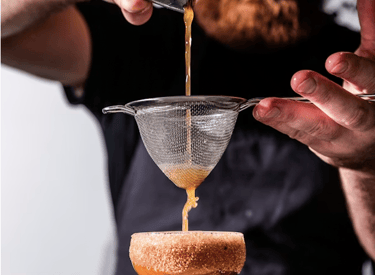 Professional mixologist preparing a handcrafted cocktail for a private event.