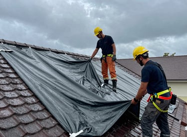 A professional roofer carefully inspecting a residential roof under clear skies.