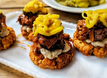 Spicy Garbage Plate-inspired tater tot cups topped with burger, meat sauce, macaroni salad, mustard