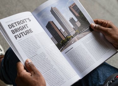 A close-up of hands holding a notebook filled with handwritten community ideas against a backdrop of Detroit street art.
