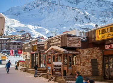 Winter village atmosphere in Val Thorens, French Alps, with snowy streets, mountain views, and alpine ski lifestyle.