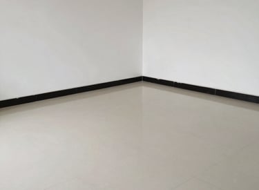 Professional cleaner using equipment to remove dust and debris from a newly constructed interior space.