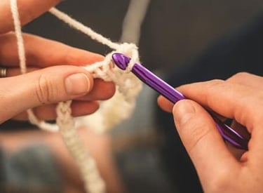 manos tejiendo a crochet con lana 