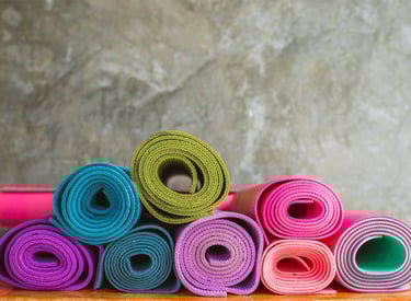 a stack of yoga mats with colorful colored yoga mats