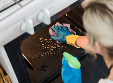 A woman deep cleaning the interior oven in a residential home