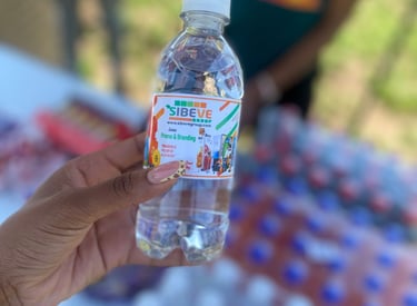a person holding a sibeve branded bottle of water in front of a table