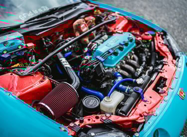 Stage 2 Remap A high-angle shot of a custom-tuned Honda engine bay featuring a vibrant red air filte