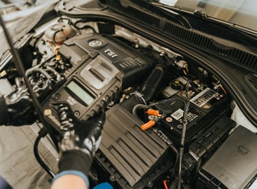 A detailed view of a car engine with a diagnostic tool connected, indicating a diagnostic service