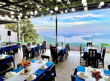 a restaurant with blue tables and chairs and a view of the ocean