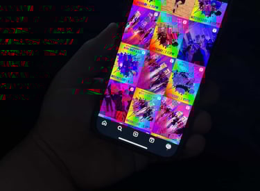 A hand holding a phone with an instagram layout on it showing different posts.