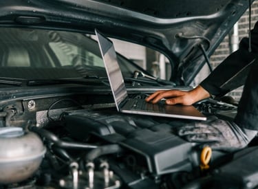 a man working on a laptop computer in a garage