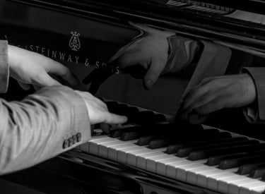Stathis Chomatsas playing piano in a concert hall during a photoshoot
