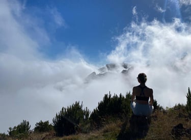 a woman in a white dress is standing on a hill