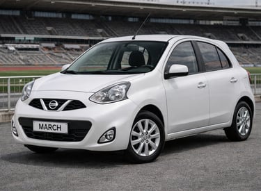carro pequeno Nissan March branco estacionado próximo a estádio