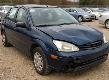 Carro usado azul com capô amassado e parachoque danificado em pátio de veículos