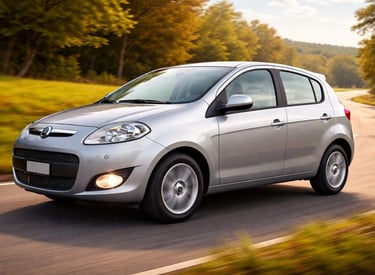 Hatch compacto em movimento em estrada rural, visto em 3/4, com cor clara e paisagem verde ao fundo,