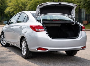 yaris sedan estacionado com porta malas aberto