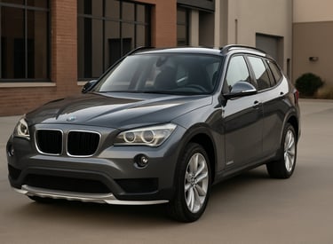 BMW X1 cinza visto de frente e lateral em ambiente urbano moderno.