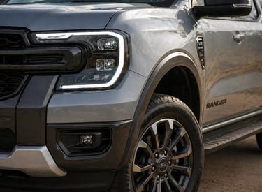 Detalhe do farol e roda da Ford Ranger prata destacando design frontal