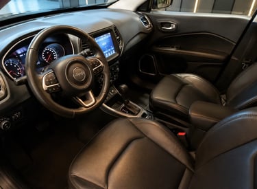 Interior do Jeep Compass 2017 com bancos de couro, câmbio automático e central multimídia